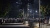 Riot police stand in formation on a road in a residential area in Yangon on February 25, 2021, as tensions rise following weeks of mass demonstrations against the military coup. (Photo by Ye Aung THU / AFP)