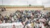 FILE - People who fled the war from May Tsemre, Addi Arkay and Zarima gather around in a temporarily built internally displaced people camp to receive their first bags of wheat from the World Food Program in Debark, Ethiopia, Sept. 15, 2021. 