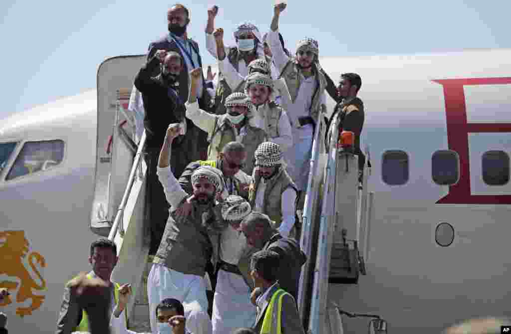 Yemeni prisoners chant slogans during their arrival after being released by the Saudi-led coalition at the airport in Sana'a.
