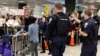 Police direct arriving passengers past dozens of pro-immigration demonstrators who cheer and hold signs at Dulles International Airport, to protest President Donald Trump's travel ban in Chantilly, Virginia, in suburban Washington, Jan. 29, 2017.