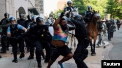 Specijalne policijske snage pokušavaju da potisnu demonstrante iz parka Lafajet blizu Bele kuće da bi predsednik Donald Tramp mogao da prođe do obližnje crkve Svetog Jovana, 1. jun 2020. godine