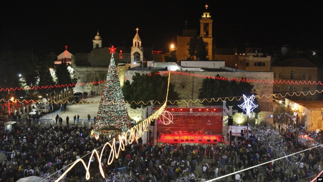 Christian worshippers and tourists celebrate at the Manger Square in front of the Church of the Nativity, in the West Bank town of Bethlehem, December 24, 2012. 