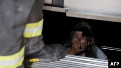 An elderly person trapped in an elevator reacts as firefighters assist in her rescue during a blackout in Santiago, Chile, Feb. 25, 2025.