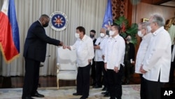 In this photo provided by the Malacanang Presidential Photographers Division, U.S. Secretary of Defense Lloyd Austin, left, does a fist bump with Philippine President Rodrigo Duterte during a courtesy call on the president at the Malacanang Palace…