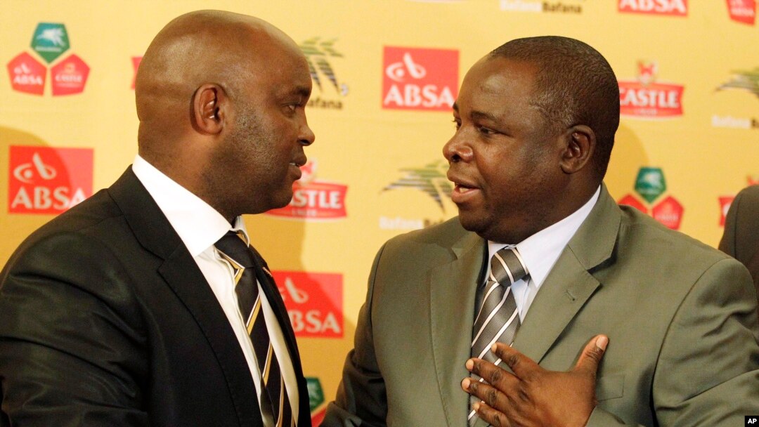 FILE - Kirsten Nematandani, president of the South African Football Association (R) shakes hands with then coach for South Africa's national soccer team Pitso Mosimane, in Johannesburg, South Africa, July 15, 2010.