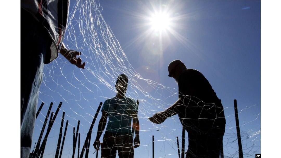 FILE - gillnetters repair a net near the mouth of the Columbia River in Astoria, Oregon, Sept. 7, 2012. President Joe Biden has ordered federal agencies to restore fish populations to Columbia River Basin.