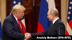 US President Donald J. Trump (L) and Russian President Vladimir Putin (R) shake hands during a joint press conference following their summit talks at the Presidential Palace in Helsinki, Finland, July 16, 2018 