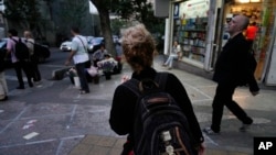 FILE - An Iranian woman not wearing a mandatory headscarf walks in downtown Tehran, Iran, June 10, 2024.