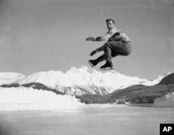FILE - US figure skater Dick Button executes a jump during a practice session at St. Moritz, Switzerland, on Jan. 19, 1948, in preparation for the Winter Olympics of 1948.