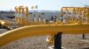FILE - Men stand next to pipelines of the national natural gas distribution network outside Ungheni, Moldova, March 4, 2015. 