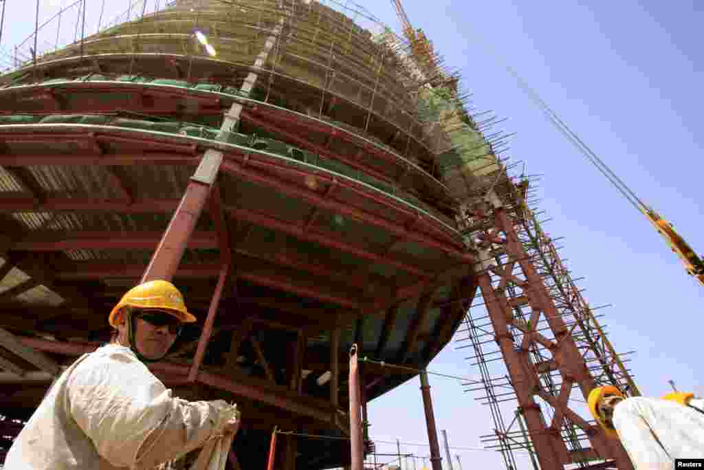 A building rises behind a Chinese engineer on the skyline of Khartoum, the capital of Sudan in 2009.