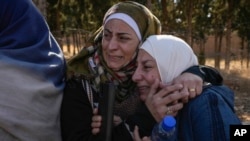 İki kadın, Şam'ın hemen kuzeyindeki Sednaya askeri hapishanesinin önünde kucaklaşıyor- 9 Aralık 2024. 