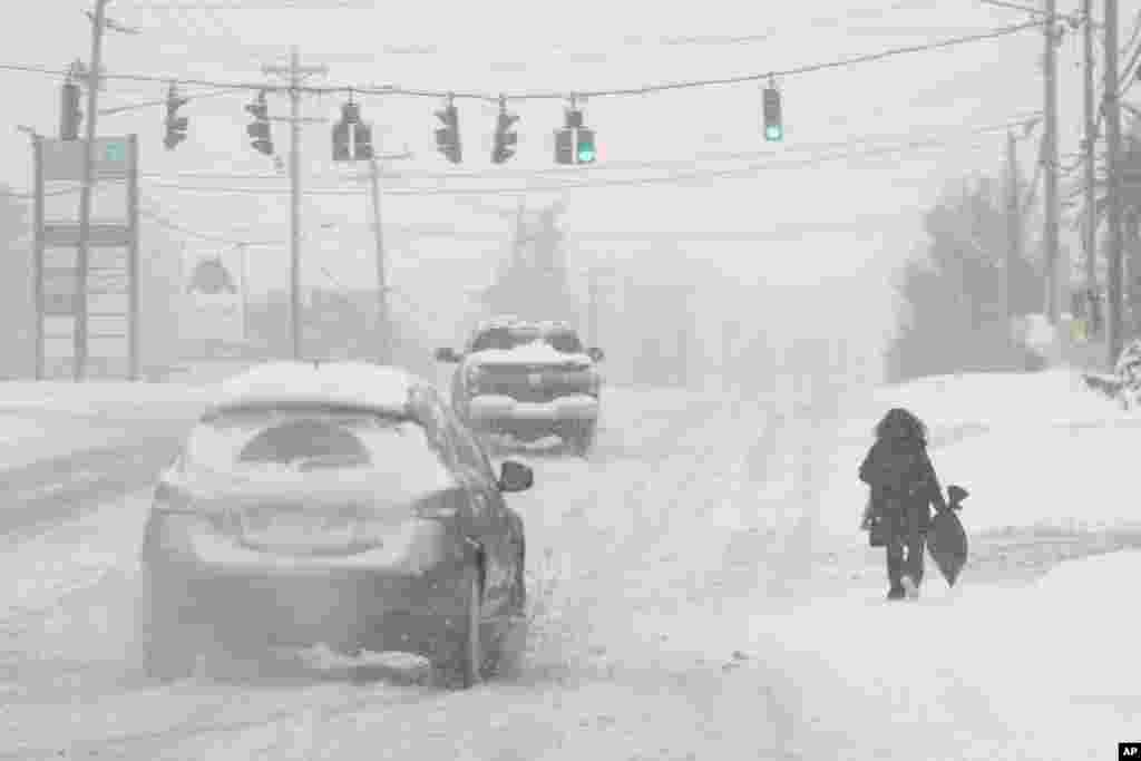 Neve forte cai enquanto uma pessoa caminha ao longo da Estrada 42 dos EUA em Florence, Kentucky, a 6 de janeiro de 2025.