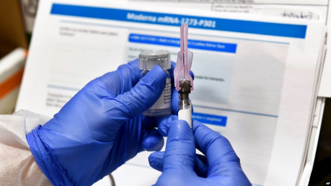 FILE - Nurse Kathe Olmstead prepares a shot that is part of a possible COVID-19 vaccine, developed by the National Institutes of Health and Moderna Inc., in Binghamton, New York, July 27, 2020.