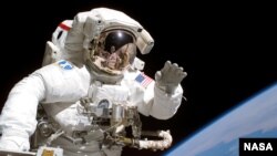 Astronaut u svemirskoj šetnji sa Zemljom u pozaini