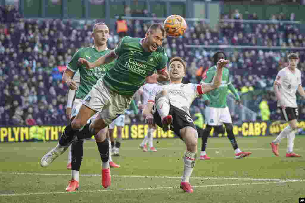 Plymouth Argyle's Nikola Katic, left, clears the ball next to Liverpool's Diogo Jota during the English FA Cup fourth round soccer match between Plymouth Argyle and Liverpool at Home Park stadium in Plymouth, England.