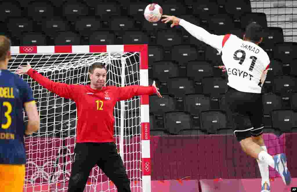 Egypt's Mohammad Sanad scores a goal past Sweden's goalkeeper Andreas Palicka during the men's preliminary round group B handball match between Sweden and Egypt at the 2020 Summer Olympics, Friday, July 30, 2021, in Tokyo, Japan. (AP Photo/Sergei Grits)