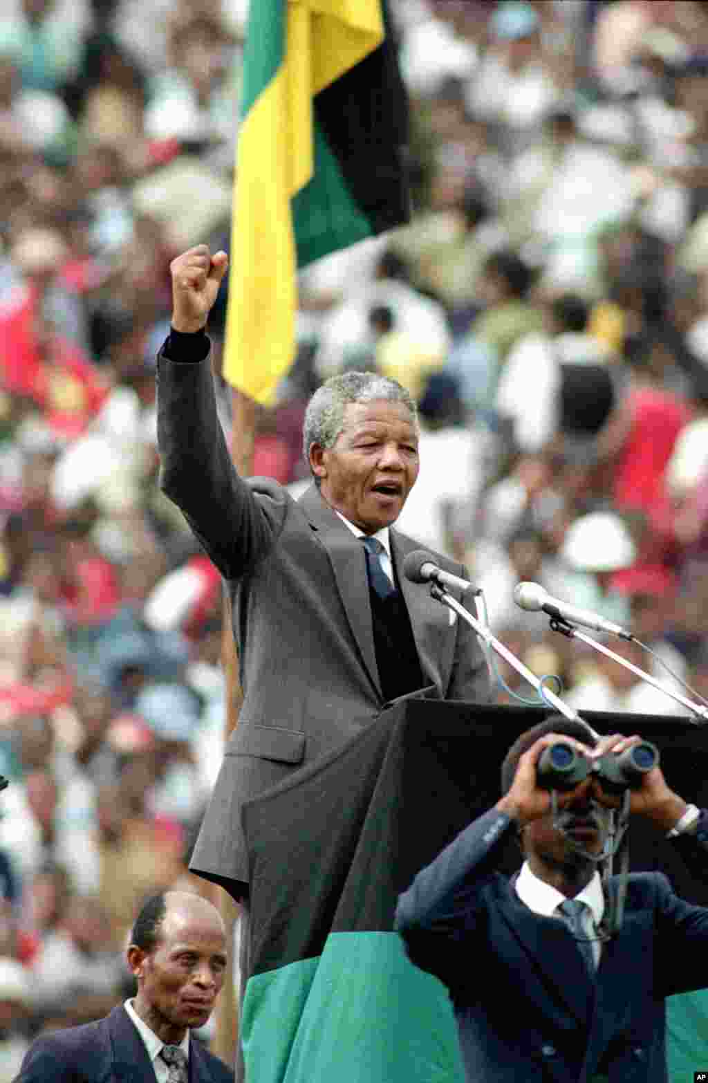 O líder do ANC e símbolo da resistência ao apartheid, Nelson Mandela, dá o cumprimento ao estilo do poder negro "black power" aos 120 mil apoiantes do ANCno Estádio de Futebol da cidade de Soweto, perto de Joanesburgo, África do Sul, Fev. 13, 1990.