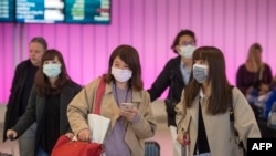 乘客在抵達加州洛杉磯國際機場時戴上防護口罩，以防冠狀病毒的傳播（2020年1月22日）。