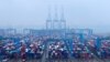 FILE - Containers and trucks are seen on a snowy day at an automated container terminal in Qingdao port, Shandong province, China, Dec. 10, 2018. 