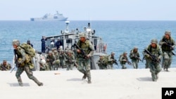 FILE - In this May 9, 2018 photo, Philippine and U.S. Marines storm a beach as part of an amphibious landing exercise during a two-week joint U.S.-Philippines exercise facing the South China Sea in the Philippines. 