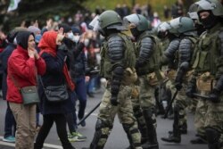FILE - Belarusian law enforcement officers block opposition supporters during their rally to reject the presidential election results in Minsk, Belarus, Nov. 1, 2020.