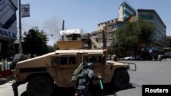 Avganistanski policajci u zaklonu dok se dim diže sa mesta napada bombaša samoubica u Kabulu, Avganistan, 31. jula 2017. (REUTERS/Mohammad Ismail - RTS19T1U)