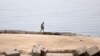 Seorang pria berjalan di salah satu dari pantai yang ditutup setelah seorang turis Rusia tewas diserang hiu di dekat pantai di resor Laut Merah, Hurghada, 9 Juni 2023. (Foto: Mohamed Abd El Ghany/Reuters)