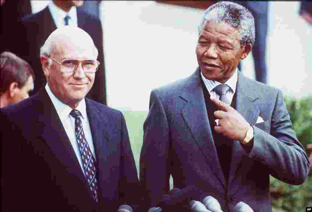 O Presidente sul-africano Frederik Willem de Klerk, à esquerda, e o Vice-Presidente do Congresso Nacional Africano (ANC) Nelson Mandela, à direita, antes das negociações entre o ANC e o governo Sul-Africano na Cidade do Cabo, Maio 2, 1990.