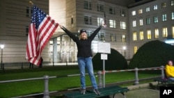 Marijen Henau iz američke države Konektikat proslavlja pobedu Džoa Bajdena i Kamale Haris ispred američke ambasade u Berlinu, pored Brandenburške kapije, 7. novembra 2020. (Foto: AP)
