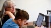 Siswa kelas 4 di Cottage Lake Elementary mencoba mencari tahu instruksi penugasan di laptopnya saat pembelajaran online yang diterapkan di Distrik Northshore School selama dua minggu akibat corona, di Woodinville, Washington, AS, 11 Maret. 2020. (Foto: Reuters/Lindsey Wasson)