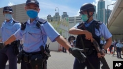 當香港首位被控涉嫌違反國安法的唐英傑坐著輪椅被押解至法院時港警戒備。（2020年7月6日）