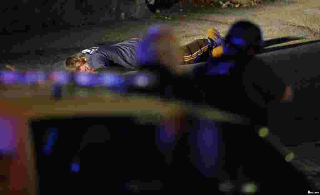 Police officers keep a man on the ground in Watertown, April 19, 2013, following the shooting of a police officer at the Massachusetts Institute of Technology (MIT).