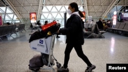 Arhiva - Putnica gura kolica za prtljag na međunarodnom aerodromu Čengdu Šuangliju usred talasa infekcija Kovida 19, u Čengduu, pokrajina Sečuan, Kina, 30. decembra 2022.