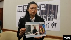 李明哲的妻子李淨瑜2017年3月向媒體展示李明哲以往活動的照片。(資料照片) 