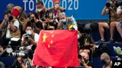 巴黎奧運前夕，多名西方游泳選手針對深陷興奮劑醜聞的中國隊提出質疑。圖為東京奧運泳池畔觀眾持五星級為中國游泳選手加油。