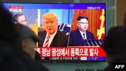 Ljudi gledaju televizijski program preko ekrana na kome se vide fotografije američkog predsednika Donalda Trampa i severnokorejskog lidera Kim Džong Una, na železničkoj stanici u Seulu, Južna Koreja, 29. novembra 2017.