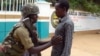 An armed security officer checks a student entering the Garissa university college, in Garissa, Kenya, on Jan. 4, 2016. 