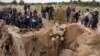 Warga masyarakat menyaksikan Menteri Kepolisian Afrika Selatan, Senzo Mchunu, memeriksa bagian luar terowongan tambang tempat ratusan penambang ilegal diperkirakan bersembunyi di bawah tanah, di Stilfontein, Afrika Selatan, 15 November 2024. (Ihsaan Haffejee/REUTERS)