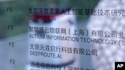 An AI robot moves past an office information board showing the DeepSeek smartphone apps company in Beijing, Jan. 28, 2025. China has been using Google's artificial intelligence-enabled Gemini chatbot to supercharge cyberattacks against U.S. targets.
